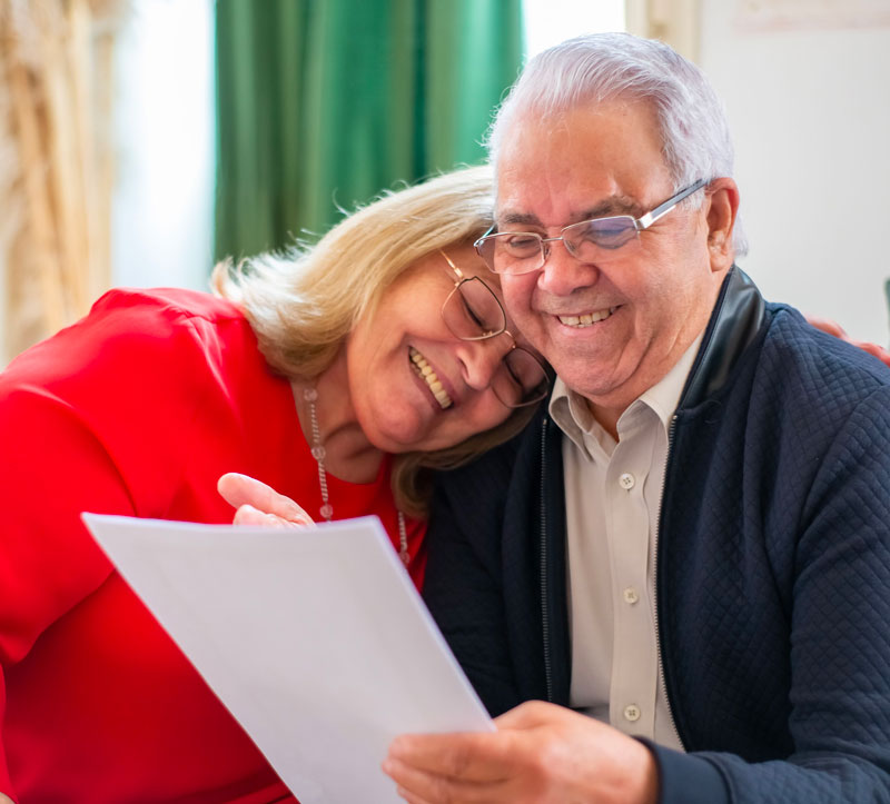 Couple de seniors lisant un tableau de garanties de complémentaire santé