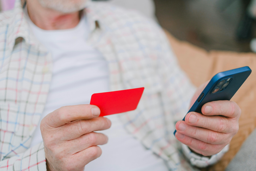 Senior utilisant une tablette pour faire un achat en ligne depuis son domicile