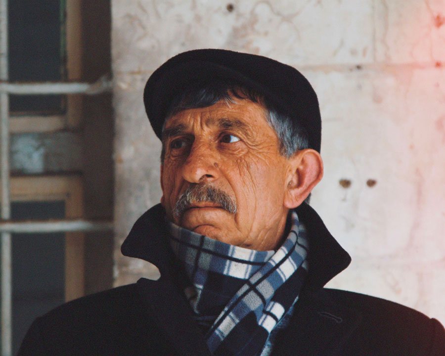 Homme âgé en casquette et écharpe à carreaux, chaudement habillé pour l’hiver